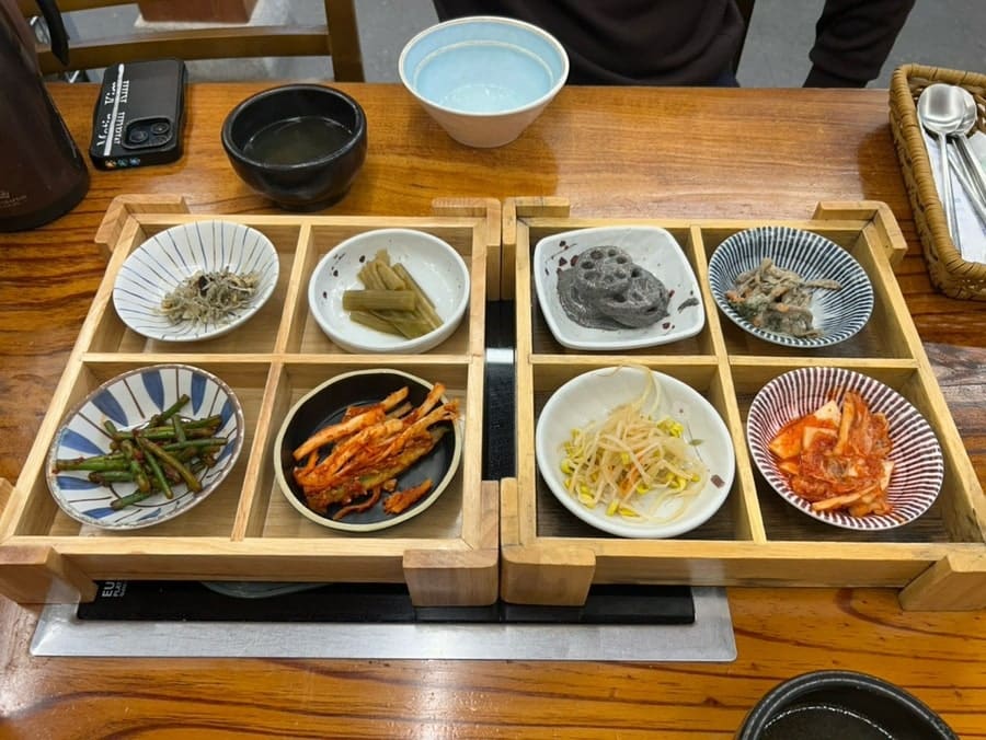 6yeargap이 남긴 우대갈비솥밥과 밑반찬입니다. 뼈째 올라온 갈비와 노릇한 누룽지, 여덟 칸짜리 반찬함이 한 상에 함께 놓여 있습니다.