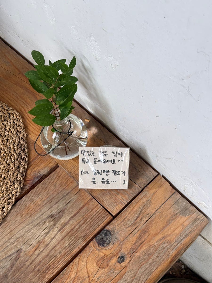 eyj3919가 담은 벽면과 안내문입니다. 경주 곳곳을 찍은 사진들이 테이프로 붙어 있는 벽 아래로 파우치와 가방이 진열돼 있고,