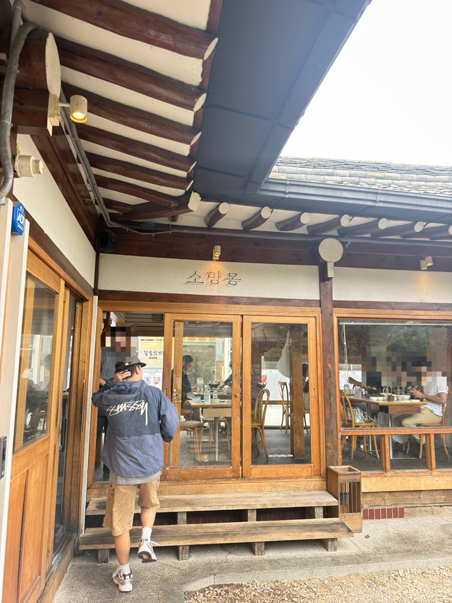 joojoolee_가 담은 나무 대문 앞 풍경입니다. 소향몽이라는 글씨 아래로 손님들이 드나드는 모습에서, 이 문 앞이 사진 명소로도 통한다는 말이 그대로 느껴집니다.