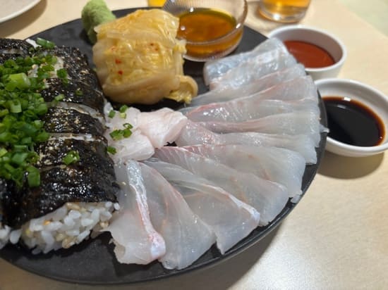 useless10님이 남긴 사진입니다. 부챗살처럼 펼쳐 낸 광어회와 김밥, 묵은지 쌈까지 한 접시에 담겨 나오는 모습입니다. 광어와 묵은지,