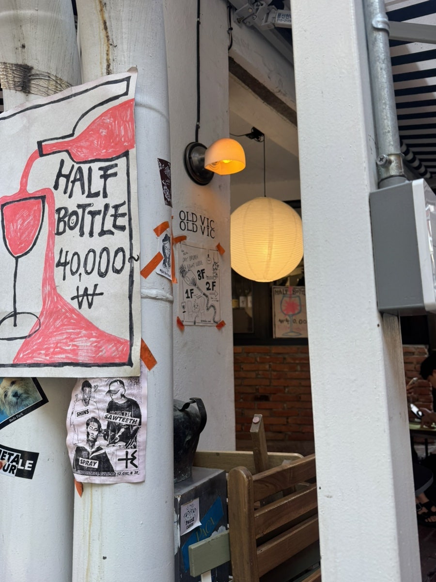 간판을 찾기 힘들었다는 손님은 벽돌 벽과 접이식 통유리창, 그 아래 손글씨로 쓴 'HALF BOTTLE 40,000' 안내지를 먼저 찍었습니다.