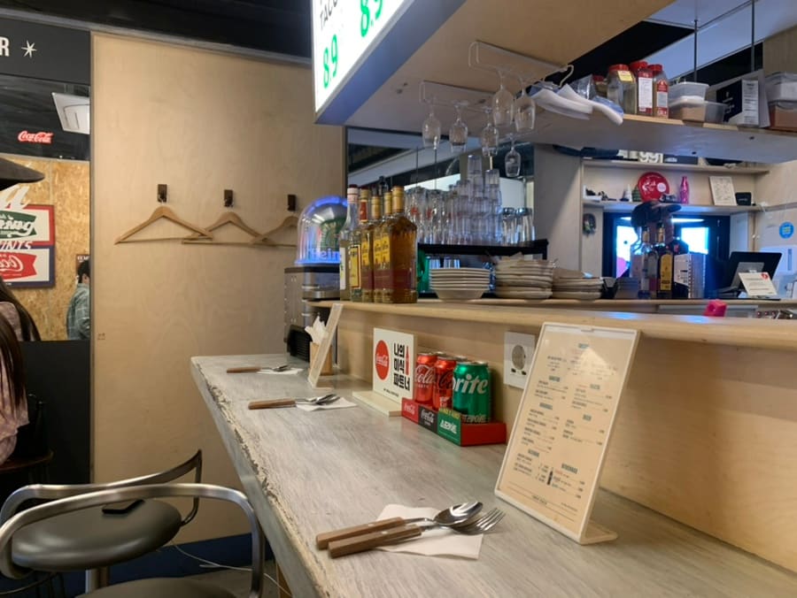 화분과 유리병이 놓인 입구의 입간판과, 위스키와 잔이 걸린 바 카운터입니다. 시그니처 팁시 타코의 된장과 과카몰리 조합을 추천한다고,