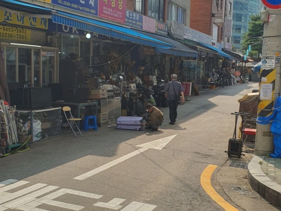 jsyou2994가 촬영한 청계천 교차로와 만물상 골목 입구입니다. 신호등 옆 이정표가 서울풍물시장 방향을 가리키고 있어, 지금은 다른 동네에 있는 그 시장의 흔적을 보여줍니다.