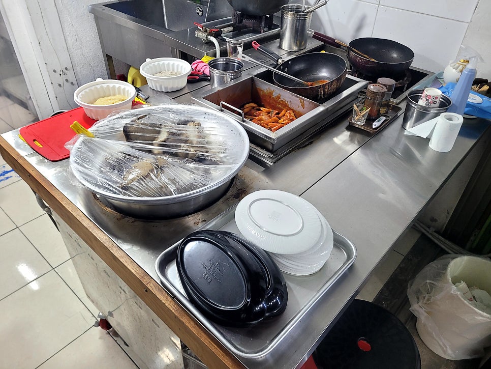 gkdudtjr2가 촬영한 스테인리스 찜기들과 조리대입니다. 여러 겹으로 쌓인 찜기 사이로 새우만두가 삼베 위에 올려져 있고,