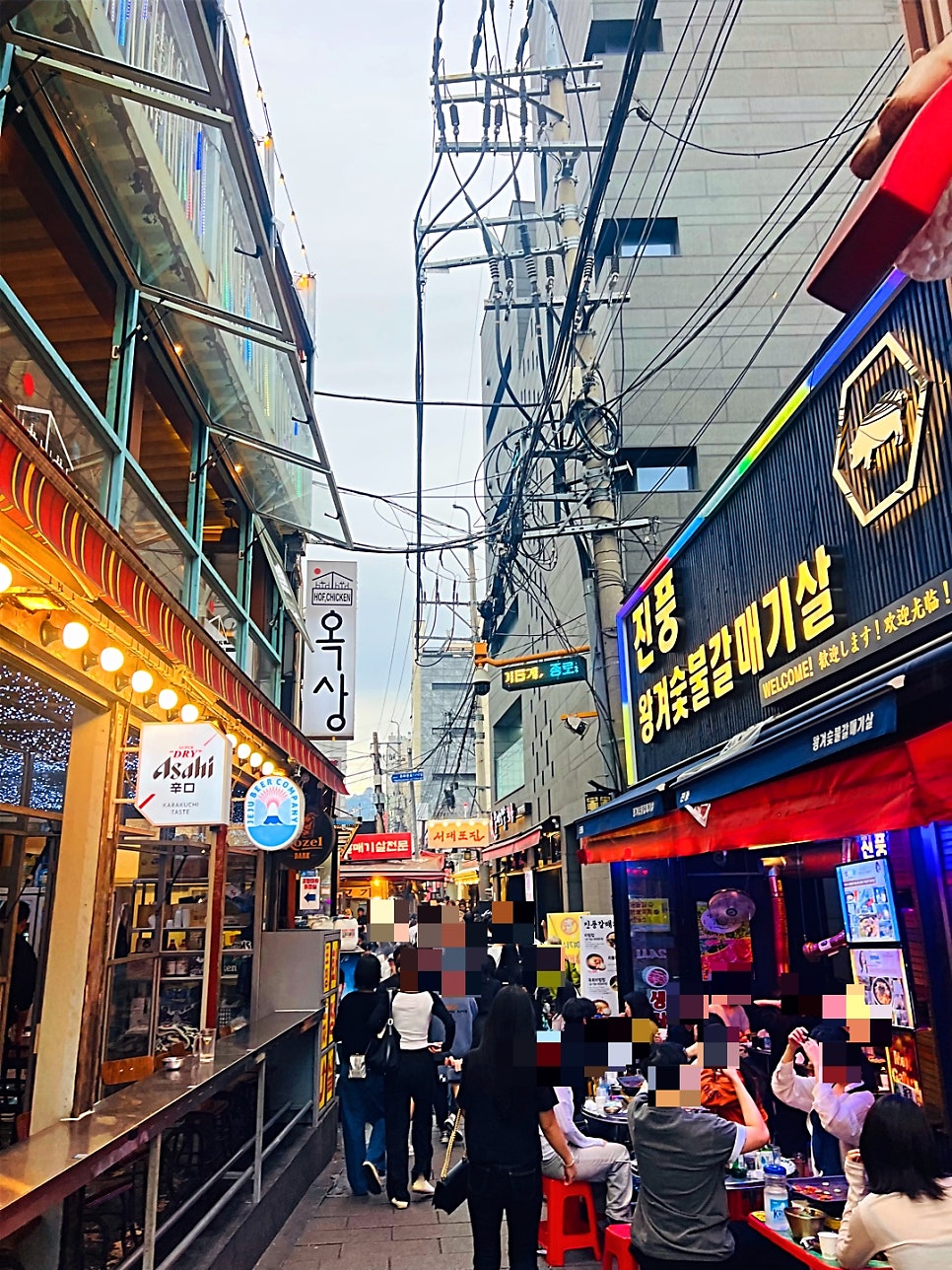 lks1361은 간판부터 오래된 맛집 느낌이 뿜뿜한다고 적었습니다. 한지를 두른 '꽃 피는 풍년집' 기둥 간판과, 저녁이면 네온 간판으로 붐비는 갈매기살 골목을 함께 담았습니다.