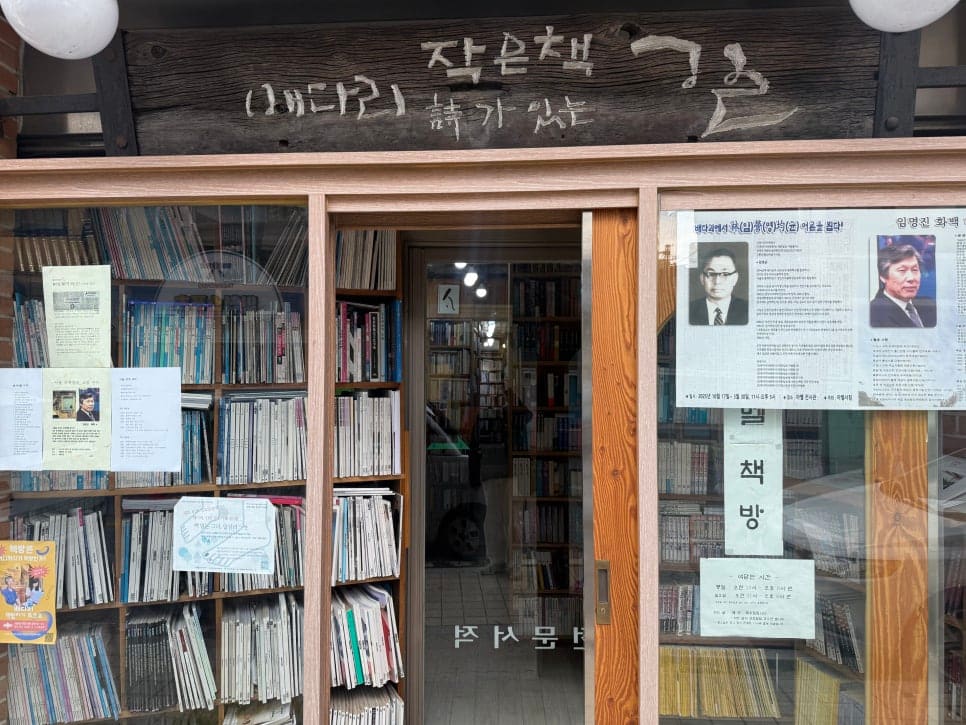 rsakesi1이 담은 아벨서점의 문 앞과 안쪽입니다. 손글씨 간판과 신문 스크랩이 붙은 유리창,