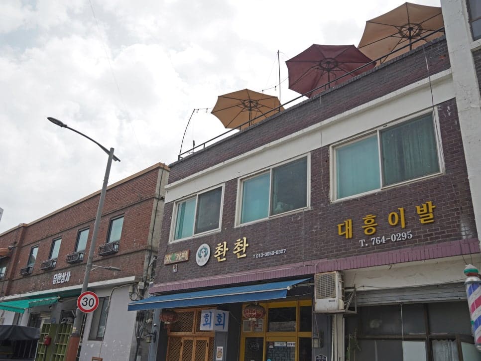 파라솔이 올라간 낮은 상가 건물들이 이어진 골목 하늘과, 책방 안 구리색 선풍기 너머로 빼곡한 메모지가 붙은 벽.