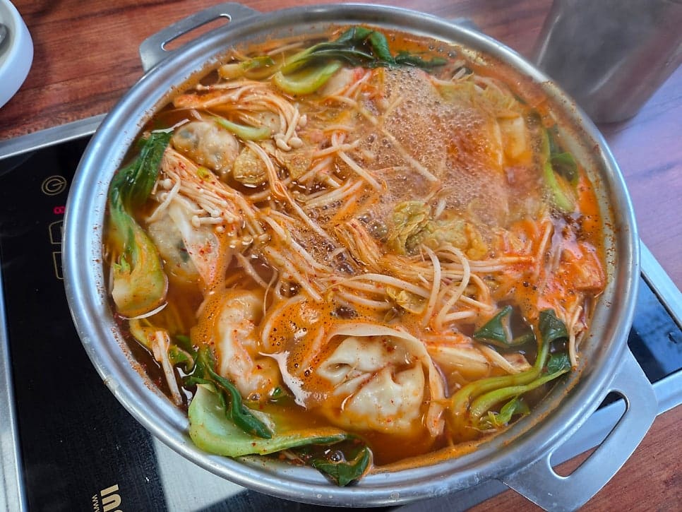 scjongchan이 담은 만두전골의 두 얼굴입니다. 만두와 버섯, 숙주, 배추를 얹어 갓 받았을 때와, 인덕션 위에서 한참 끓어 국물이 붉게 우러난 뒤의 모습을 함께 남겼습니다.
