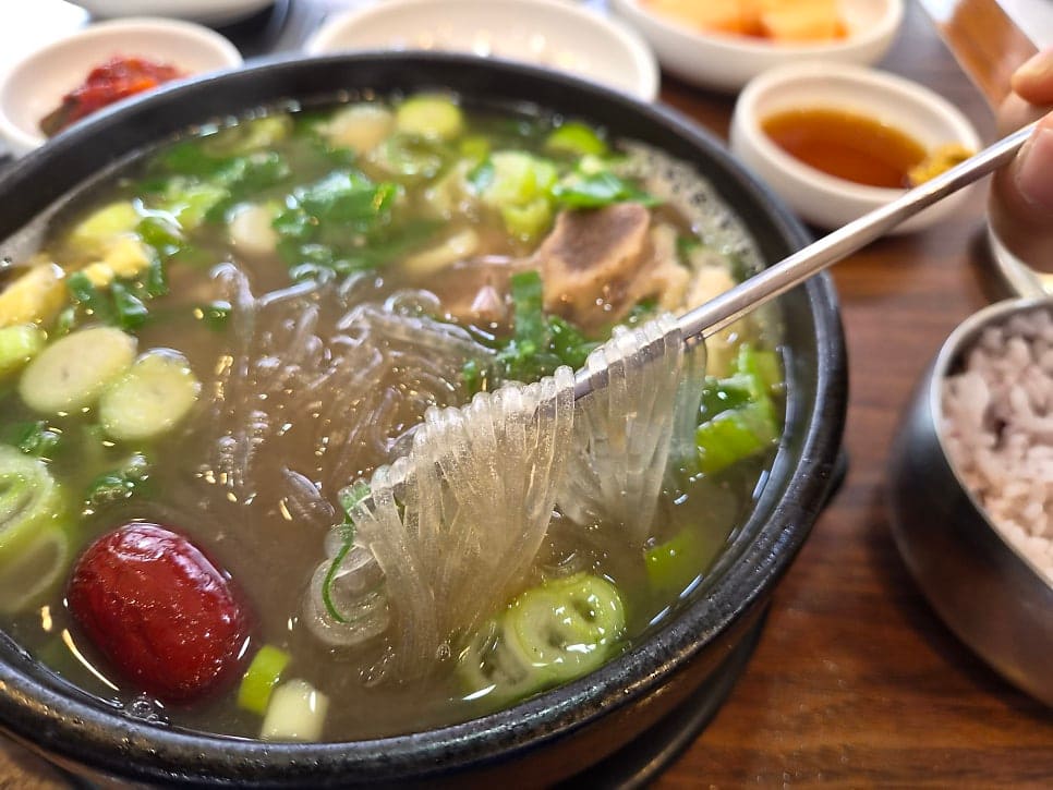 seosanpark이 남긴 사진입니다. 깍두기·장아찌·멸치볶음이 오른 기본찬 상과, 젓가락으로 당면을 건져 올리는 순간을 함께 담았습니다.