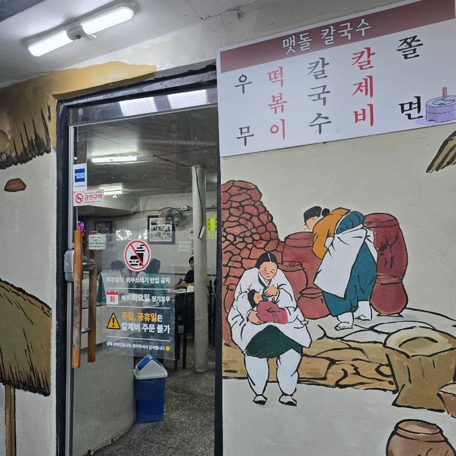 dins_log가 남긴 사진입니다. 해질 무렵 골목 모퉁이 외관과, 맷돌·절구를 든 사람들이 그려진 벽화가 있는 입구를 함께 담았습니다.