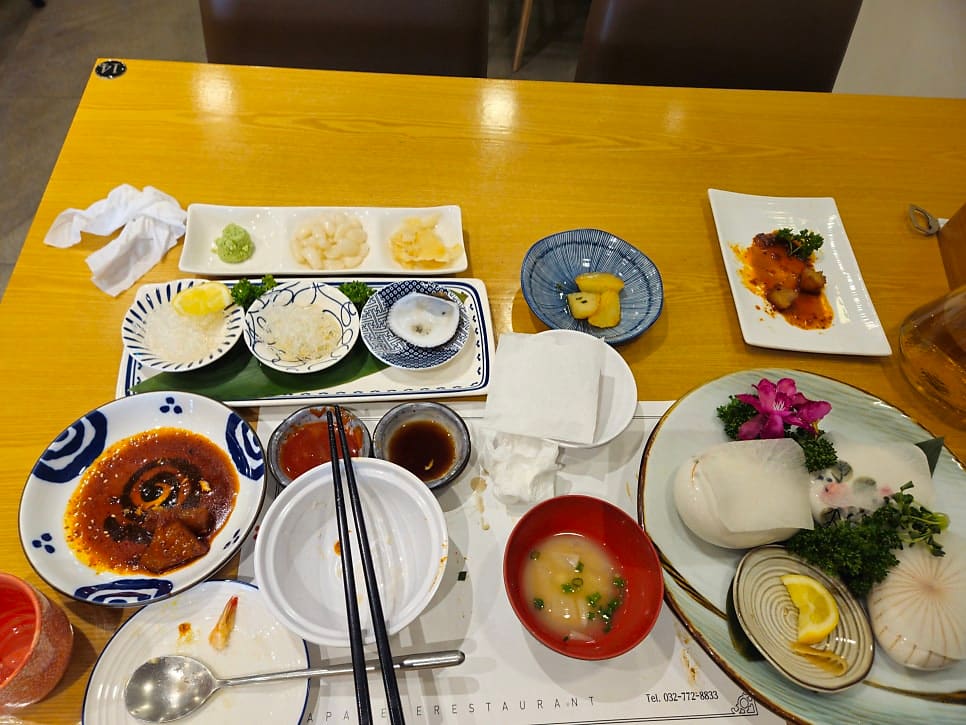 kevin6227이 남긴 사진입니다. 포도 넝쿨이 그려진 노렌과 나무 격자로 나뉜 일본풍 실내, 그리고 사시미·조림·국물이 함께 오른 런치세트 A코스 한 상을 담았습니다.