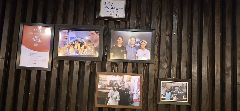 rorm00이 남긴 사진입니다. 니은자 모양으로 주방을 둘러싼 다찌석 바 테이블과, 벽에 나란히 걸린 상패와 방송 촬영 당시 사진들을 담았습니다.
