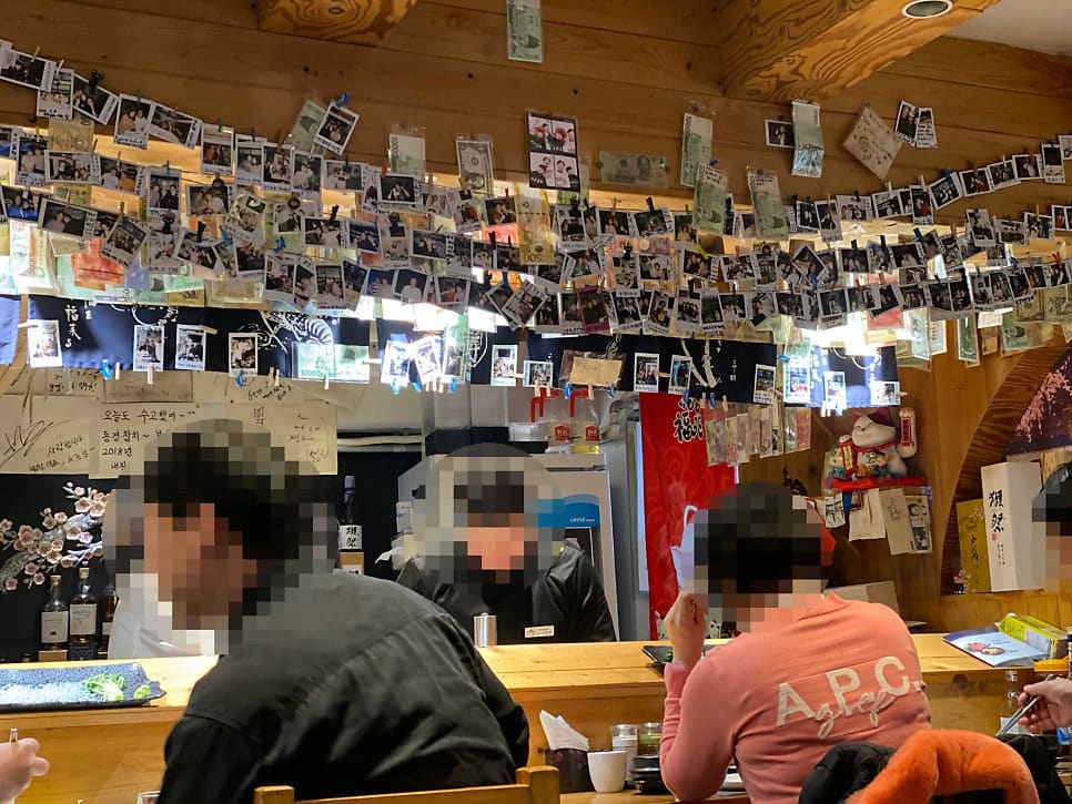 ryuggomi가 남긴 사진입니다. 정갈하게 세팅된 테이블과, 천장 가득 매달린 손님들의 폴라로이드·지폐 장식을 함께 담았습니다.