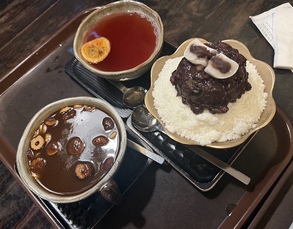 cookmom9628은 나무 벽에 걸린 커다란 오너먼트 장식과, 고등학교 친구들과 나눠 마신 대추차·쌍화차·단팥죽·팥빙수가 한 상에 오른 모습을 남겼습니다.