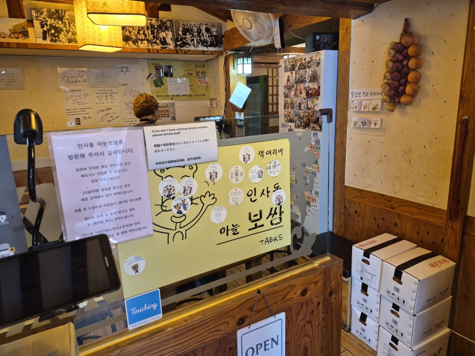 mateatji는 신발을 벗고 올라가는 좌식 공간과 원목 테이블이 늘어선 내부, 그리고 연예인 사인과 사진이 빼곡히 붙은 카운터 벽을 함께 찍었습니다.