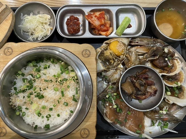 nov9206은 달걀노른자를 올린 해물장과 갓 지은 솥밥을, rpvlove는 'Traditional Korean Food' 현수막이 걸린 거리 쪽 외관을 찍었습니다.