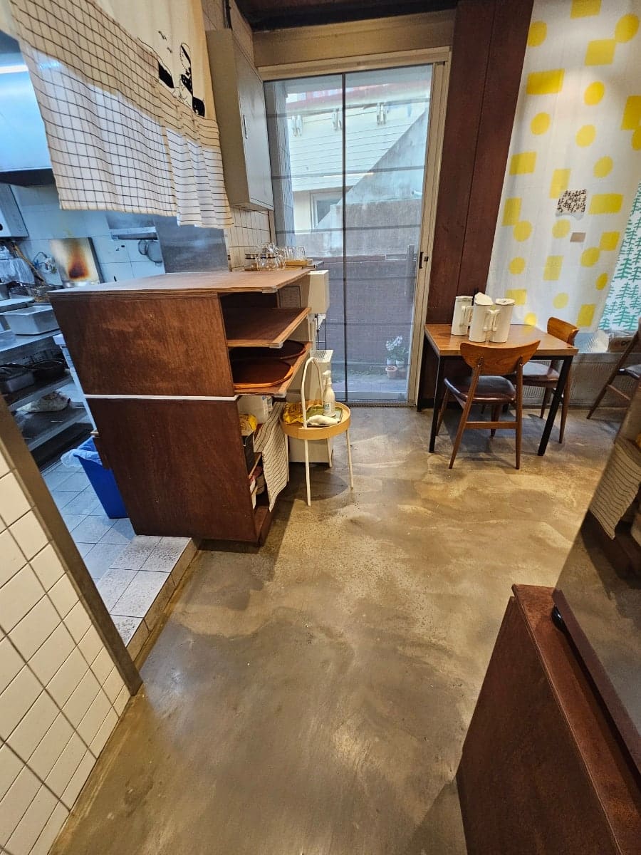 start250730(눈누난나)이 담은 주방 옆 공간과 셀프바입니다. 가정집을 개조한 듯한 구조라 시야가 층층이 꺾여 있고, 셀프바에는 김치와 단무지,