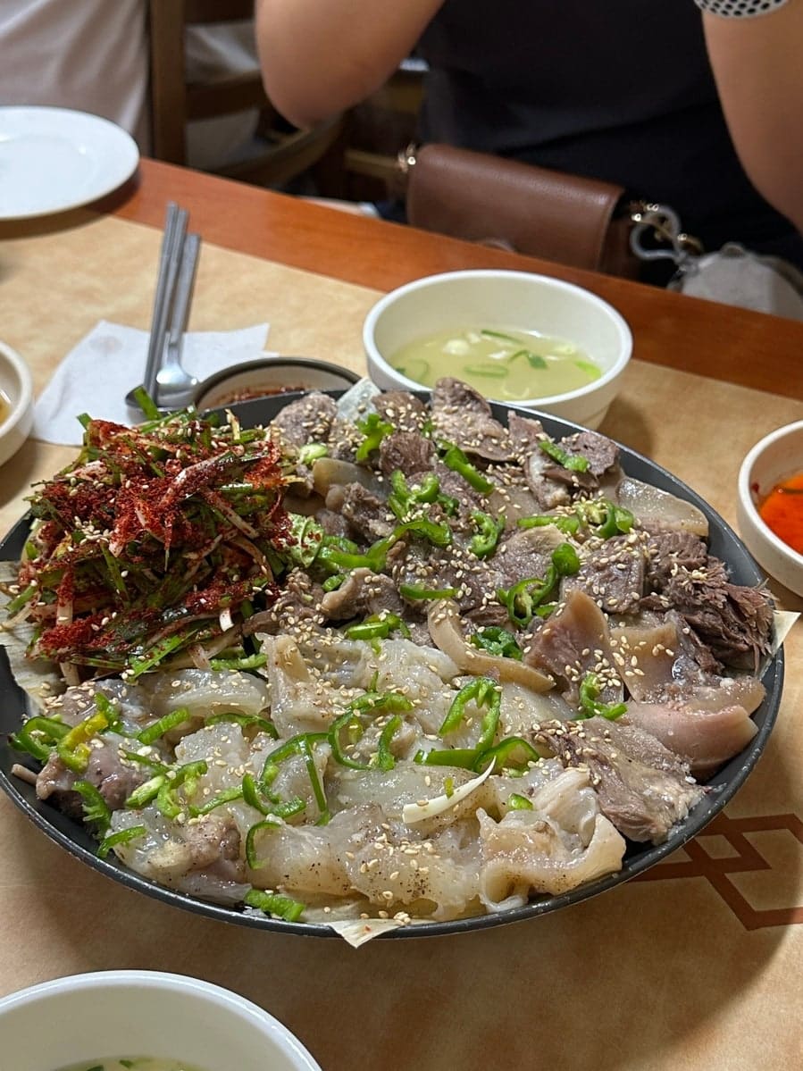 yooonse0__가 담은 한 상 전체와 반반수육 클로즈업입니다. 대나무 바구니에 담긴 잡곡밥과 소꼬리곰탕, 반반수육 접시가 상을 가득 채웠고,
