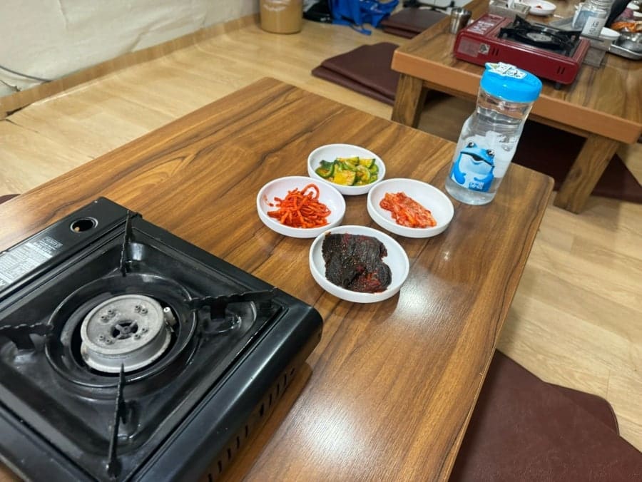cmt04는 5인이 방문해 10분쯤 기다린 뒤 안쪽 좌식으로 안내받았다고 적었습니다. 첫 사진은 좌식 테이블 위에 휴대용 버너와 반찬 접시가 놓인 모습이고,