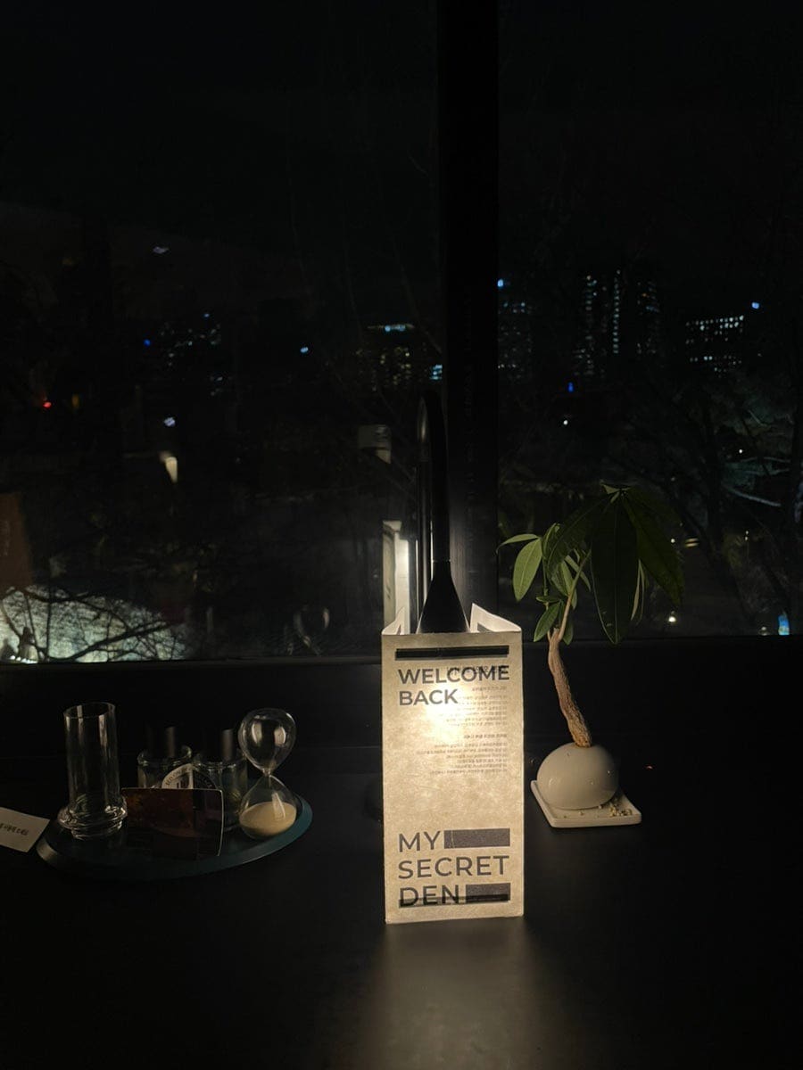 fkdlsrkd106이 담은 창가입니다. 'WELCOME BACK, MY SECRET DEN'이라 적힌 종이 조명 뒤로 정동의 밤 스카이라인이 낮게 깔립니다.