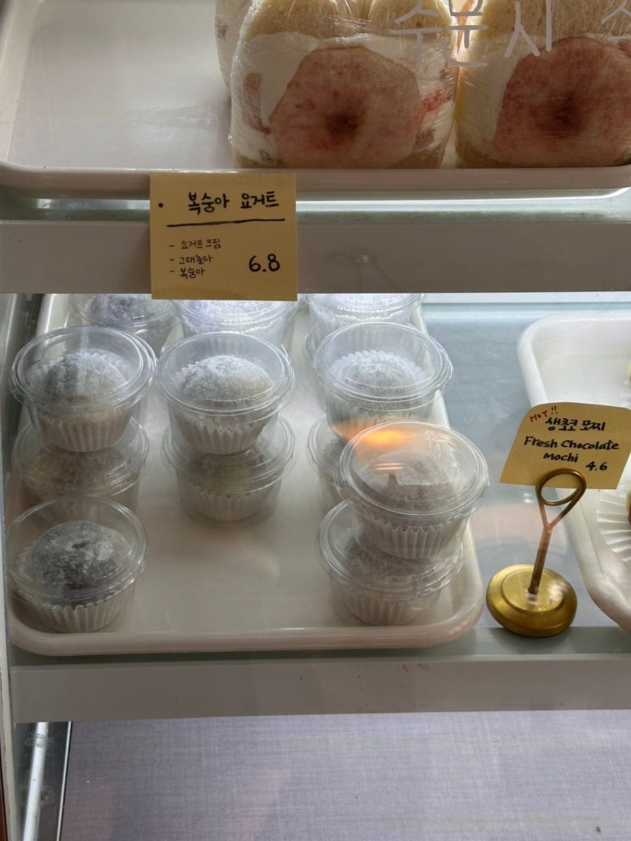 버터북을 세 번째로 찾은 끝에야 생초코모찌를 손에 넣었다는 방문자가 남긴 사진입니다. 진열대 가득 놓인 모찌와 복숭아 요거트 디저트들입니다.