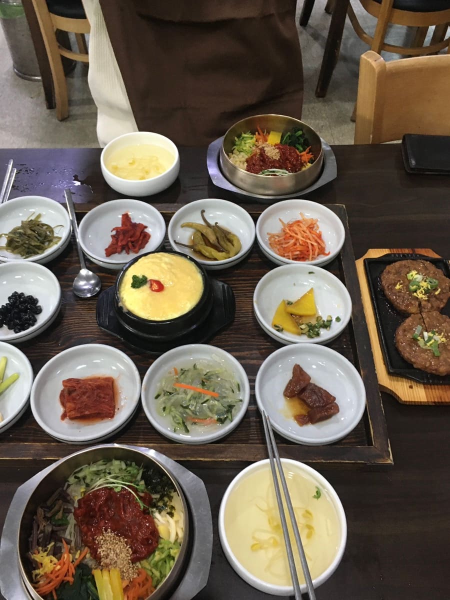 이 손님이 남긴 사진입니다. 두 그릇의 비빔밥과 떡갈비, 그리고 상을 가득 채운 반찬 접시들입니다. 메인 메뉴가 나오기 전부터 계속 손이 갔다던 반찬의 가짓수가 한눈에 보입니다.