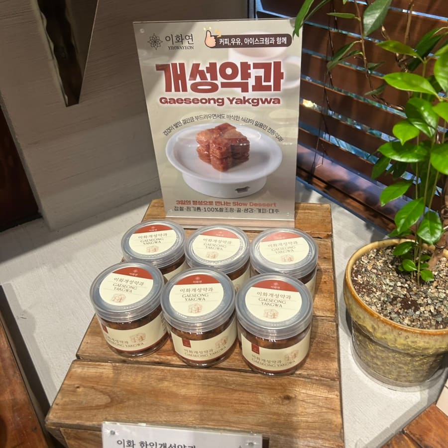 지나가다 우연히 들렀다는 손님이 남긴 사진입니다. 담쟁이 사이로 보이는 '이화연' 세로 간판과, 나무 진열대에 놓인 개성약과 유리병들입니다.