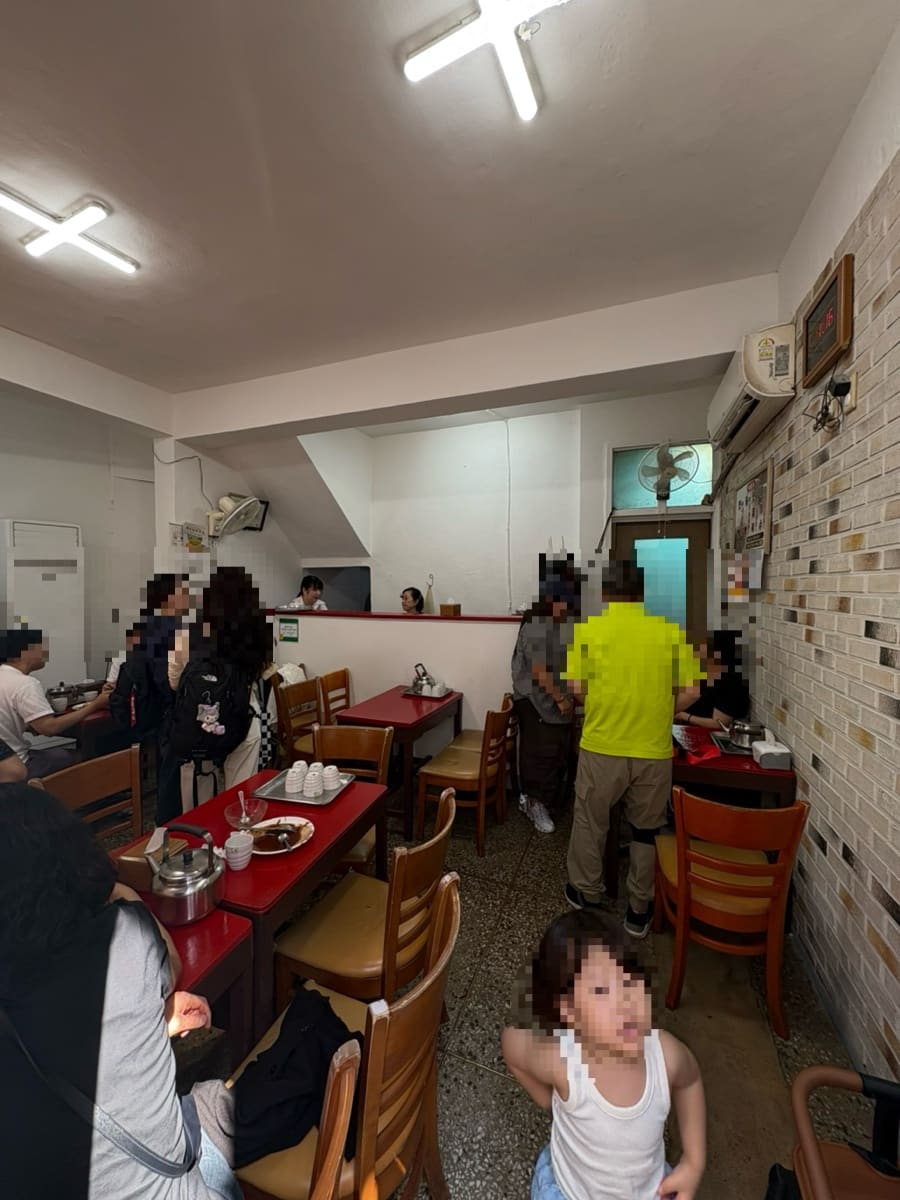 수복빵집 파란 간판과 붐비는 가게 안쪽 모습. 오래전부터 이 자리를 지켜온 빵집으로, 줄 선 손님들 사이에 아이를 데려온 가족도 보인다.
