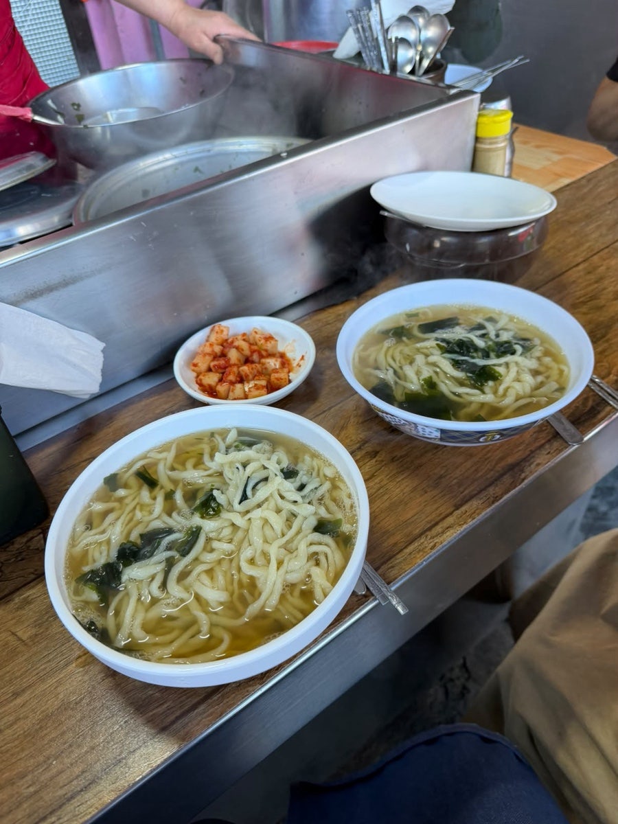 geusjh는 갓 삶아 나온 칼국수 두 그릇을 조리대 위에서 바로 찍고, 분홍빛 벽과 대나무 발 사이 야외 조리대에서 직접 면을 뽑는 모습도 담았습니다.