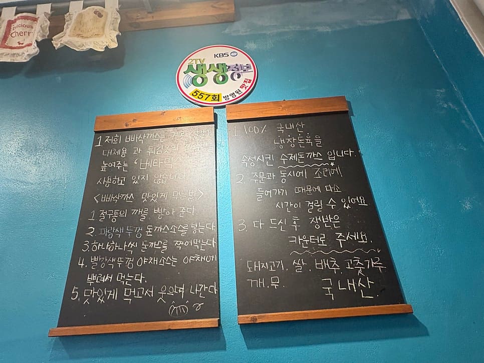 qkrrkdms03은 헤링본 타일 바닥이 깔린 좁고 긴 홀 전체와, 절구에 깨를 빻아 먹는 법을 손글씨로 적어둔 칠판을 함께 찍었습니다.