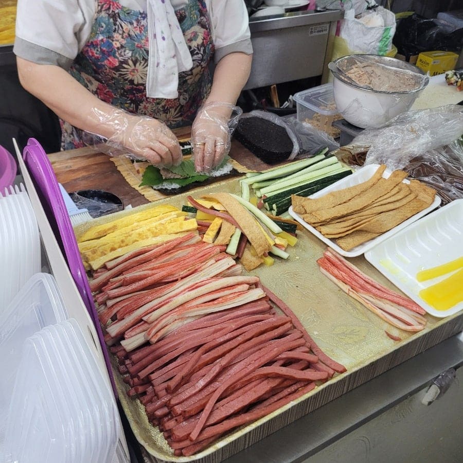 yyyuou는 사장님이 그 자리에서 김밥을 마는 손놀림과, 포장해 온 김밥의 단면을 나란히 남겼습니다. 햄과 맛살, 우엉,