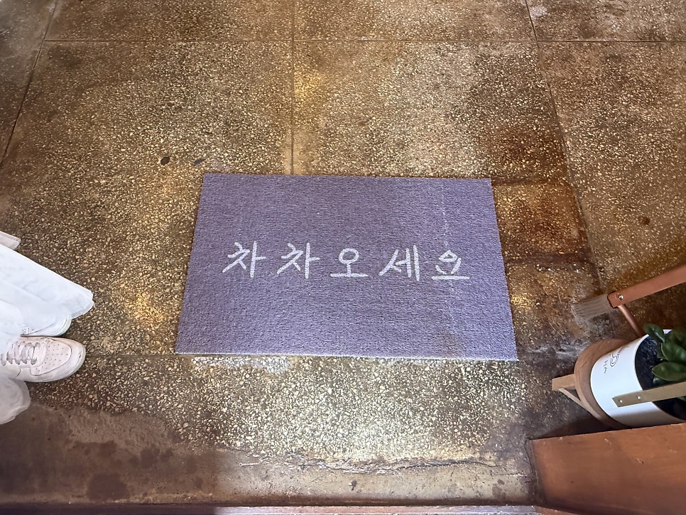 you_oo_oo는 일본식 가옥의 미닫이문과 CHACHA 나무 간판이 함께 보이는 외관, 그리고 문 앞 '차차오세요'라고 적힌 매트를 담았습니다.