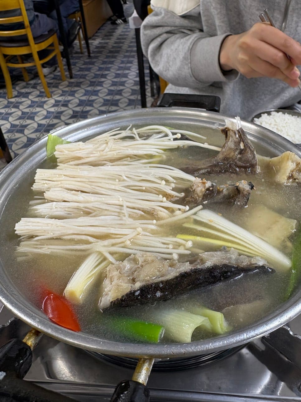 gogeum2020은 주방 화구 위에서 생선이 막 끓기 시작하는 냄비와, 테이블로 옮겨져 팔팔 끓는 우럭간국을 이어서 담았습니다.