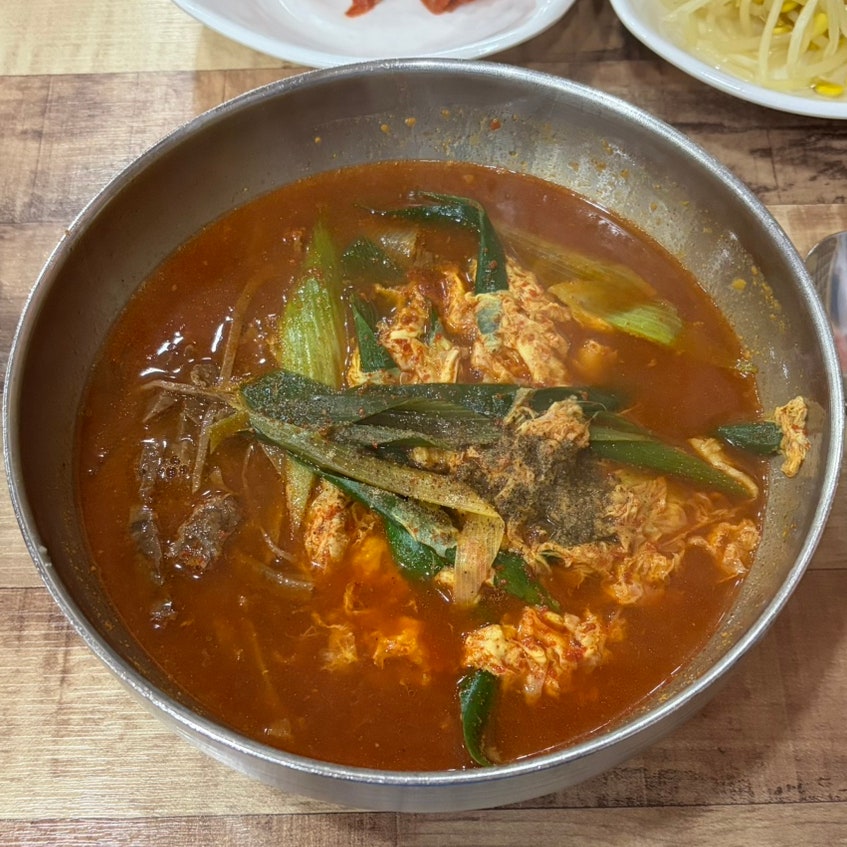 pkijj04는 깍두기·파김치·묵은지 세 가지 밑반찬과, 고기와 대파가 듬뿍 들어간 육개장을 가까이서 담았습니다. 젓갈 향이 짙어 남도의 맛이 느껴졌고,
