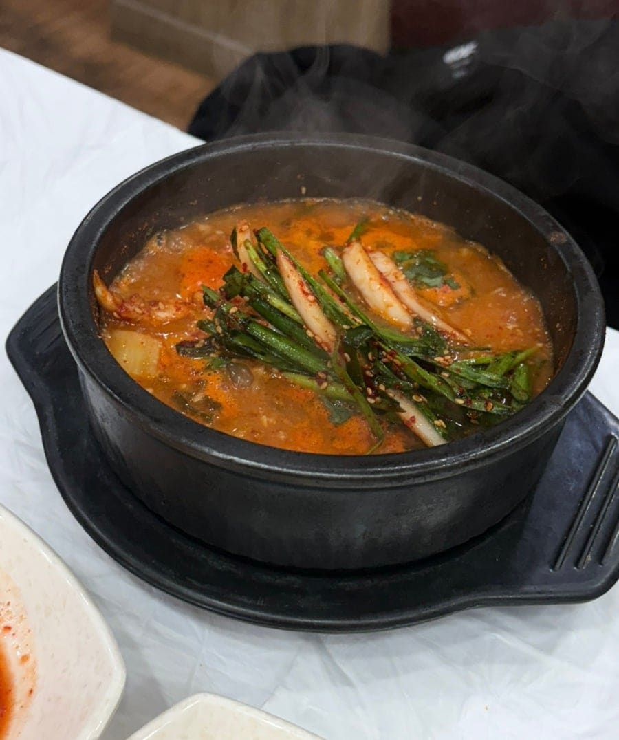 itoshii14는 흰 상보 위에 차려진 두 그릇의 장어탕과 반찬 여덟 접시를 넓게 찍고, 김이 오르는 뚝배기도 가까이서 찍었습니다.