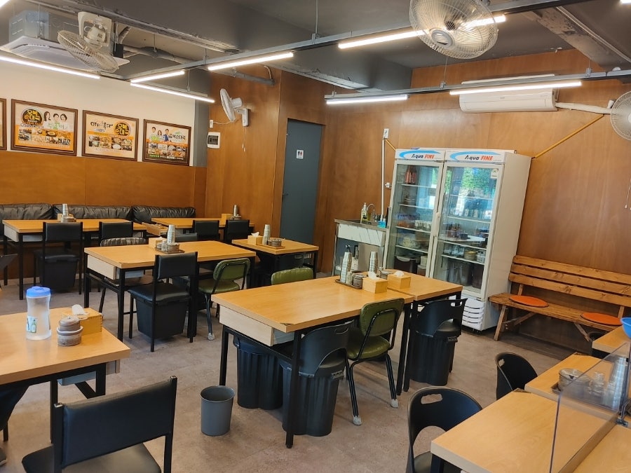 다른 블로거는 오픈 전 이른 시간에 찾아가 한산한 내부를 둘러봤습니다. 나무 패널로 마감된 벽과 방송 출연을 알리는 액자들이 나란히 걸려 있는 모습에서,