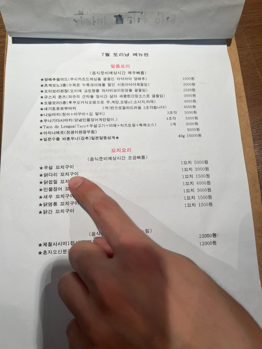 밤 열한 시, 3부로 찾은 손님이 남긴 사진입니다. 셰프가 요리하는 카운터 너머로 사케 병이 놓여 있고,