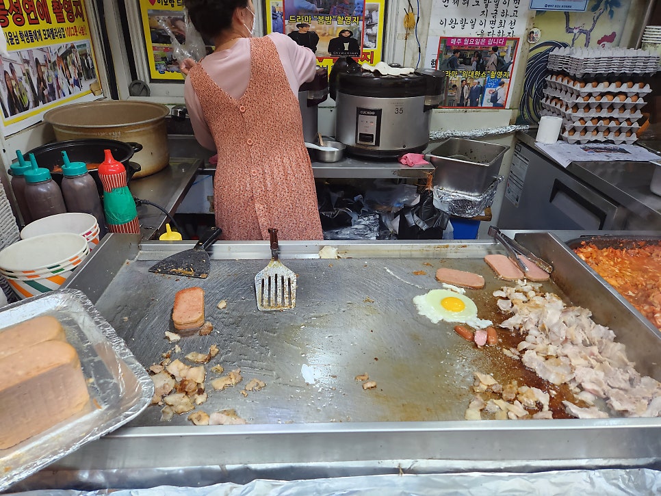 gudieearth가 기록한 노점의 철판과 완성된 컵밥입니다. 달걀과 고기를 올려 즉석에서 비벼내는 손길에서 이 골목의 속도가 드러납니다.