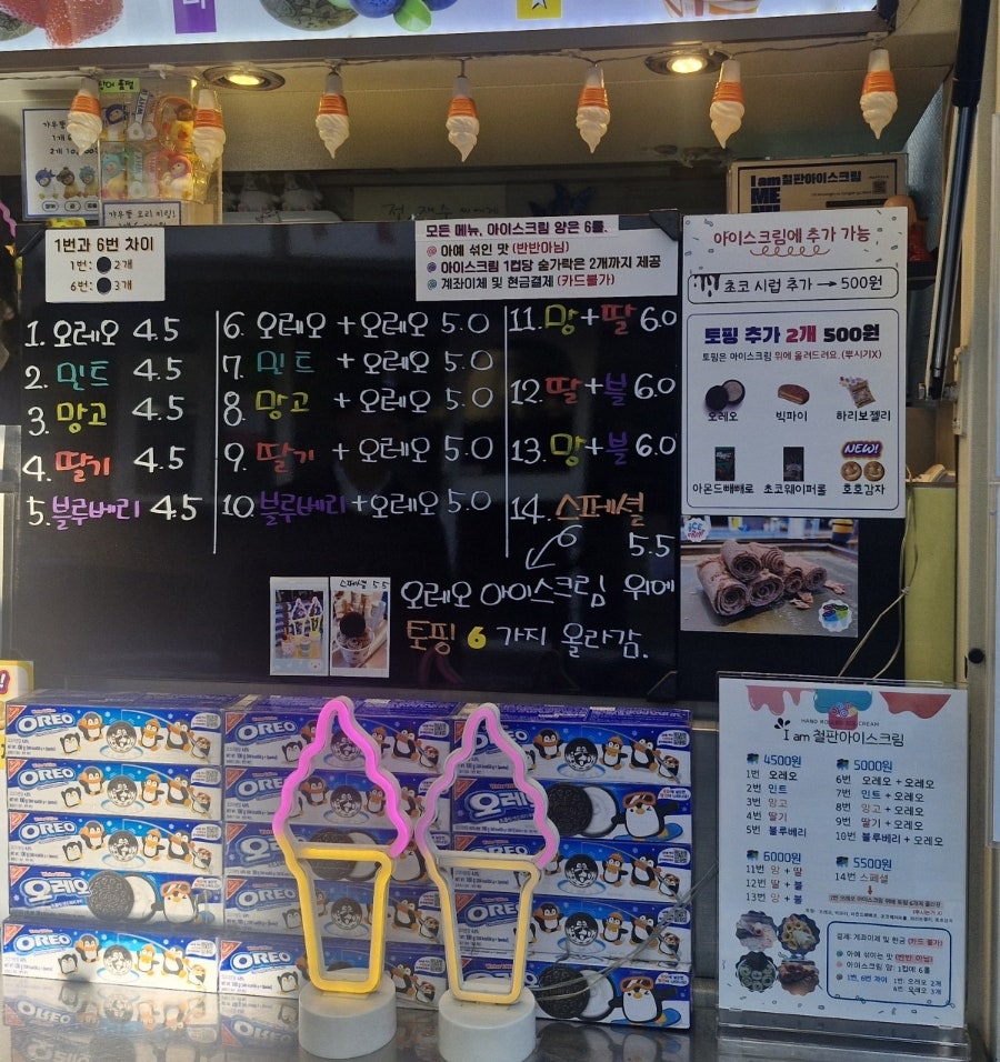 jinilog22가 담은 철판아이스크림 노점입니다. 간판과 메뉴 LED 보드 앞에 손님이 줄을 서 있고, 오레오 등 다섯 가지 맛을 고를 수 있는 칠판 메뉴판도 함께 보입니다.