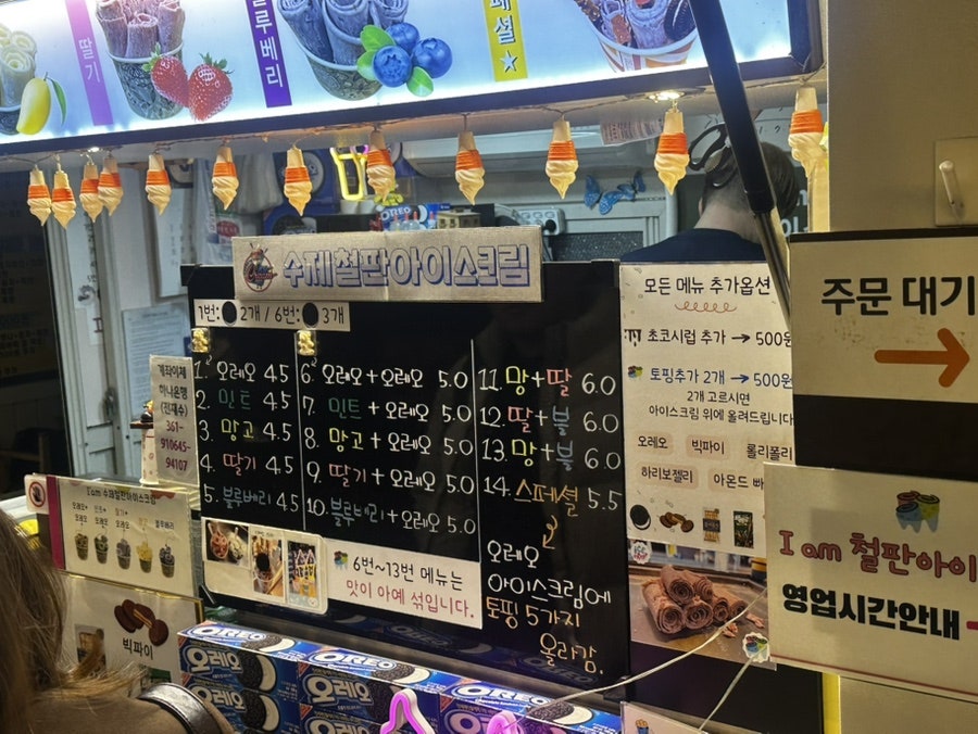 wlgid4066이 담은 조리 장면입니다. 차가운 철판 위에서 아이스크림을 펴 바르는 손길과, 토핑 추가를 안내하는 문구가 가까이서 보입니다.