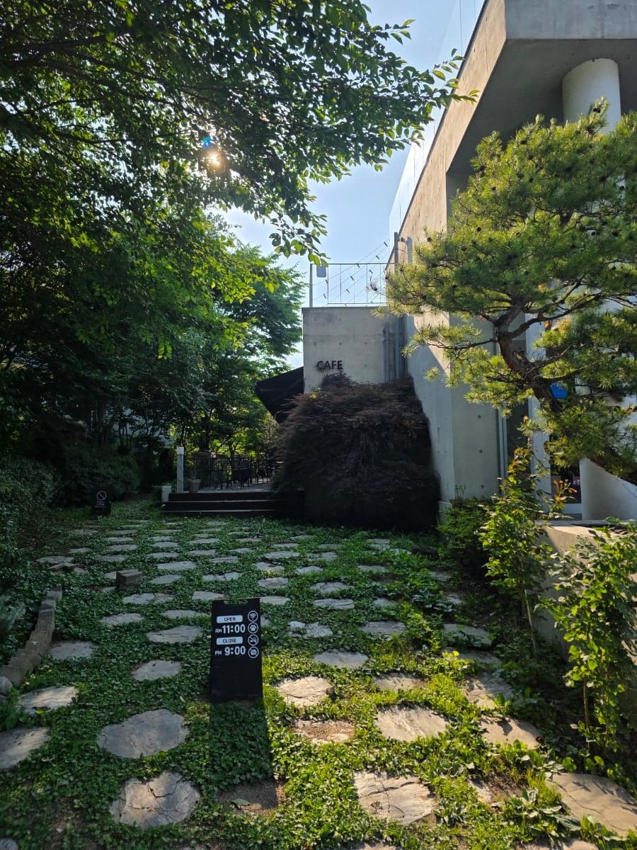 kmjj0402는 외관부터 갤러리를 연상시키는 감각적인 콘크리트 건물이 시선을 사로잡았다고 적었습니다. 계단 위로 회색 벽이 솟은 건물 앞 모습과,