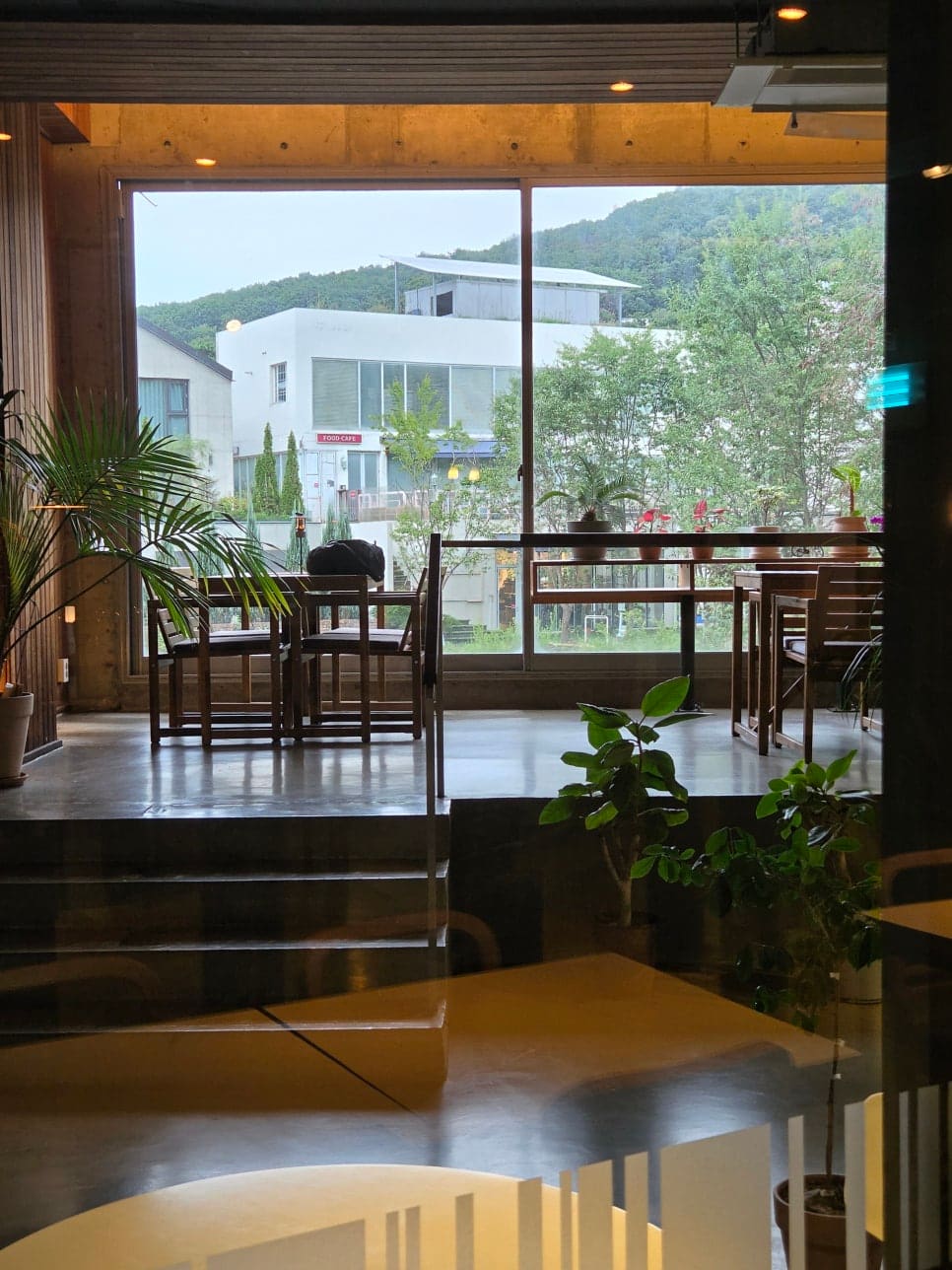 41og4는 이 집의 핵심이 통창이라고 적었고, 우드 테이블에 얹은 라탄 조명과 벽에 걸린 큼직한 회화가 따뜻한 느낌을 준다고 했습니다.