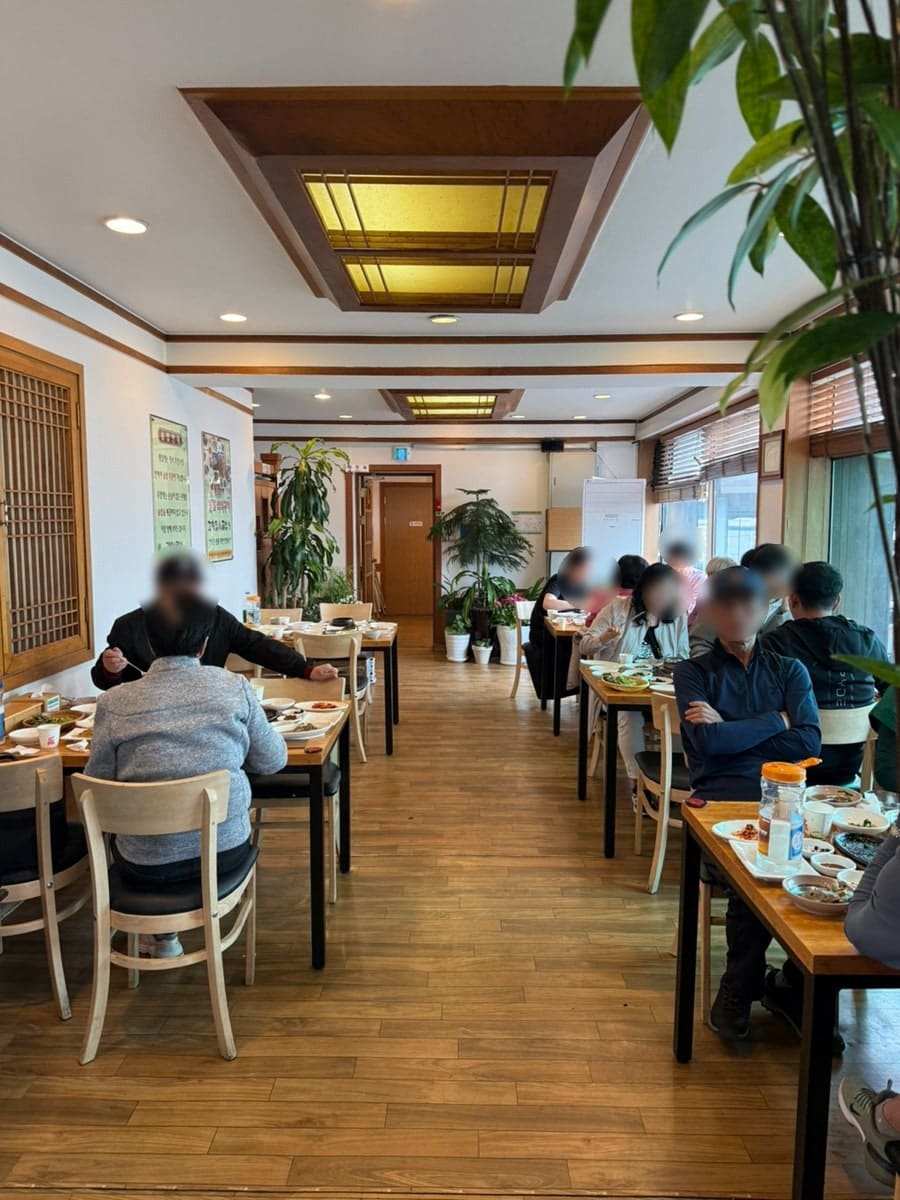 nkkm0819는 이 집이 어르신들에게 인기가 많고, 주말 식사 시간에는 사람이 굉장히 많이 몰린다고 적었습니다. 사진에는 나무 테이블마다 빼곡히 자리한 손님들과,