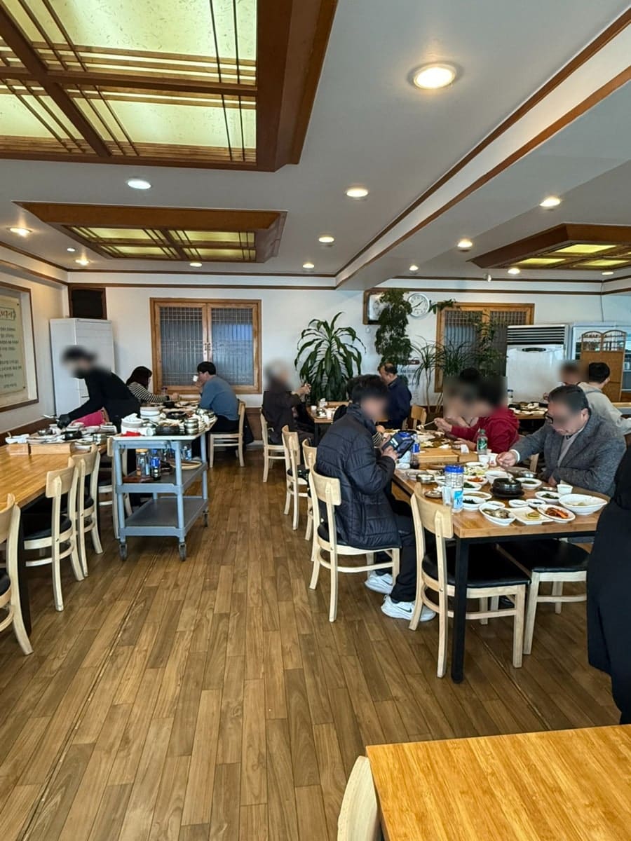 nkkm0819는 이 집이 어르신들에게 인기가 많고, 주말 식사 시간에는 사람이 굉장히 많이 몰린다고 적었습니다. 사진에는 나무 테이블마다 빼곡히 자리한 손님들과,