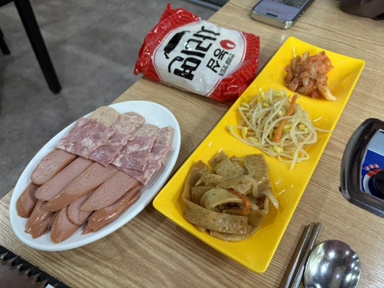 dmsdhr2528은 셀프바에 무말랭이무침과 콩나물, 김치가 놓여 있고 먹을 만큼만 덜어 가라는 안내문이 붙어 있었다고 적었습니다. 사진에는 집게가 꽂힌 밑반찬 통과,