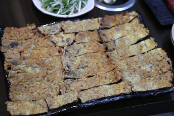 titttii는 가장 먼저 기억에 남는 메뉴로 한우 육전을 꼽으며 계란 옷이 얇아 고기 본연의 촉촉함이 살아 있다고 적었습니다. 사진에는 검은 판 가득 노릇하게 부쳐진 육전과,