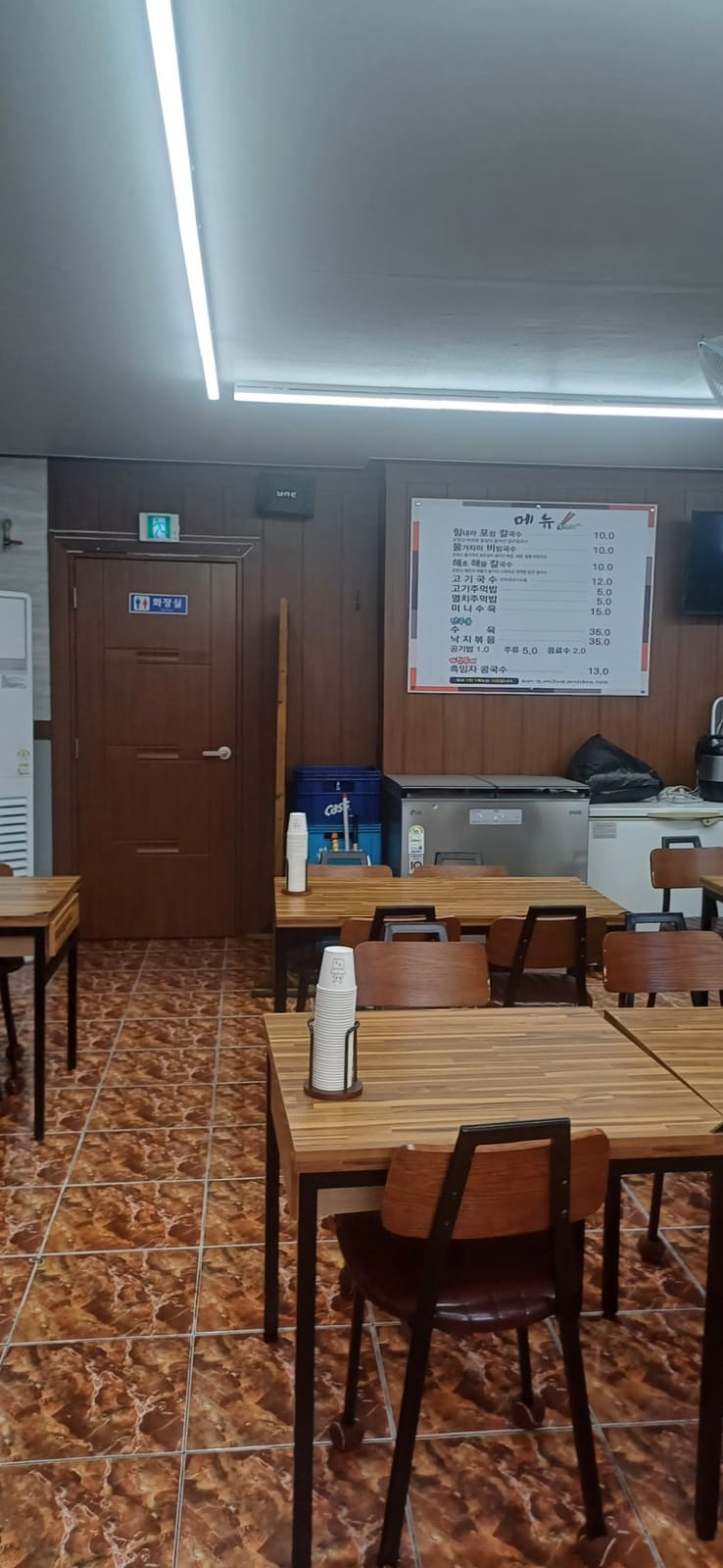 같은 블로거가 매장 안쪽을 찍은 사진입니다. 벽에는 방송 출연 당시 사장님이 연예인과 함께 찍은 액자가 걸려 있고, 2층 난간 위 선반에도 작은 상장과 소품들이 올라가 있습니다.