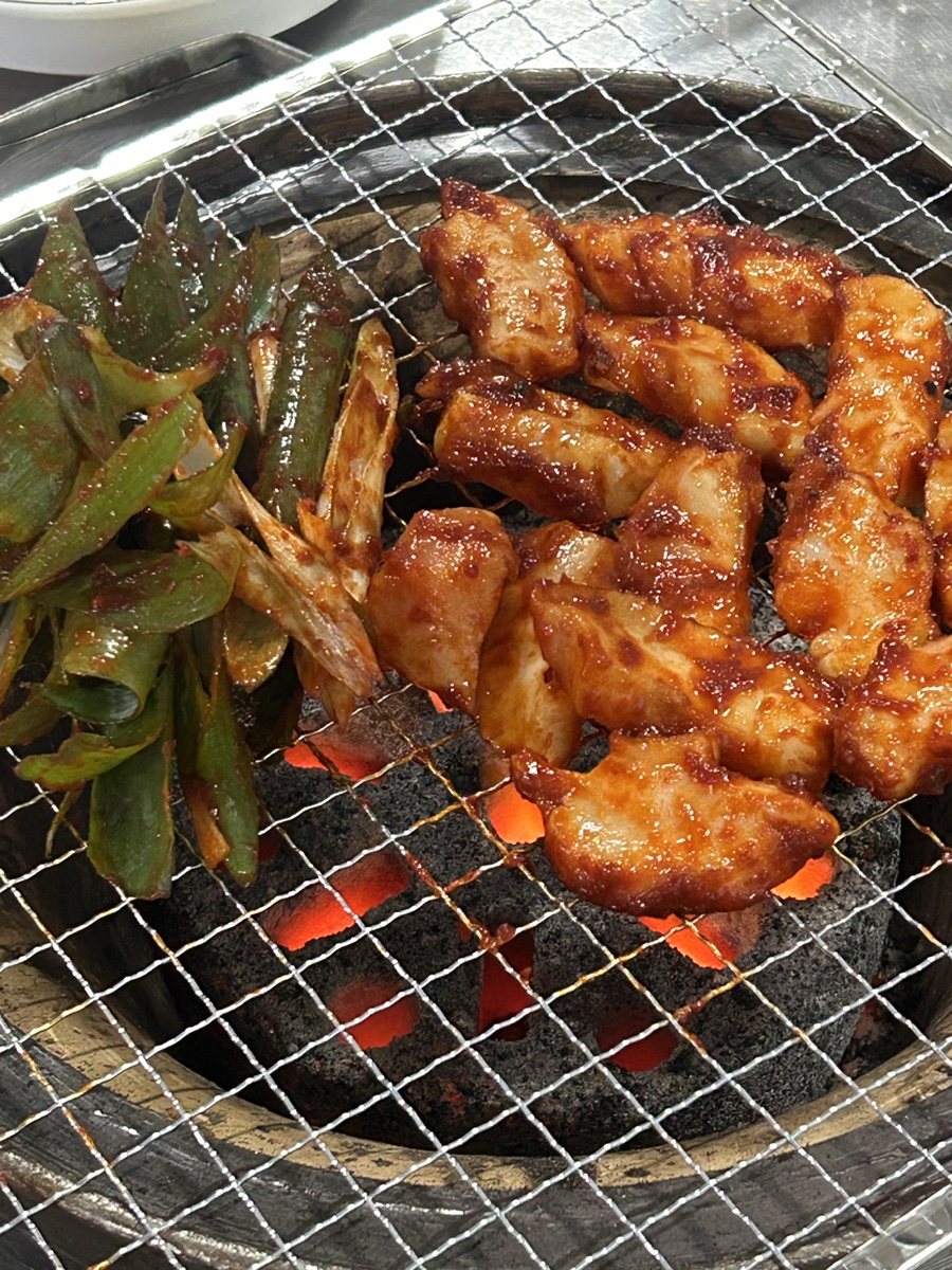imim30가 올린 사진입니다. 연탄불 위에서 대파와 함께 구워지는 대창이 빨간 양념을 두른 채 노릇하게 익어가고, 곁들여 나온 목이버섯무침과 양배추샐러드,