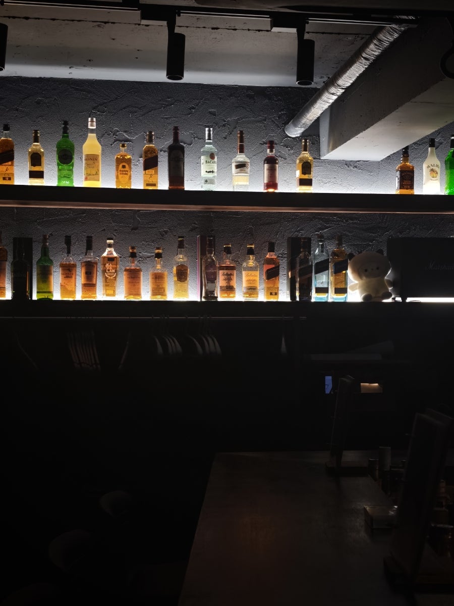퇴근길에 들렀다는 silu_는 둥글게 둘러앉은 바 카운터 전경과, 조명 아래 줄지어 선 위스키 병 선반을 함께 담았습니다.