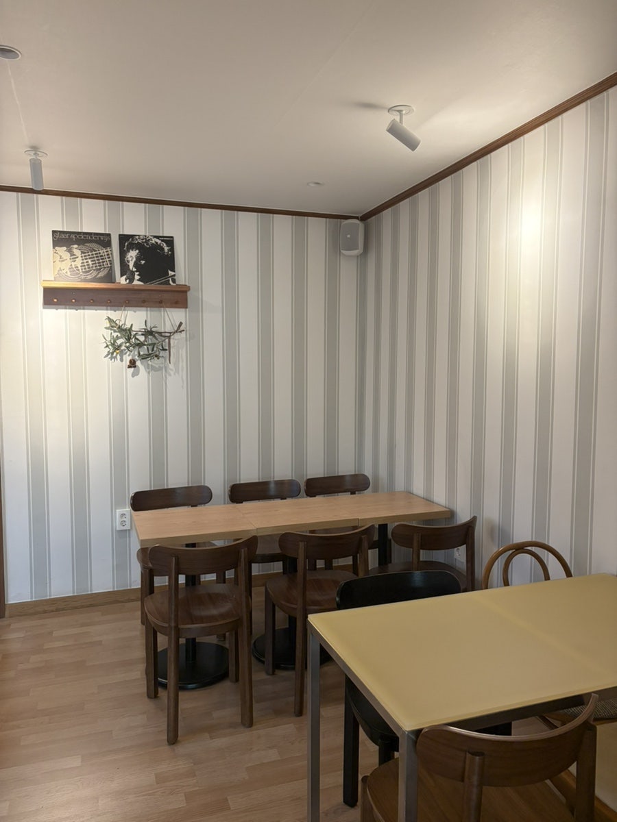 dlwndud1927은 'KOPITIAM SINGAPORE TOAST CAFE' 로고가 박힌 바 카운터와, 줄무늬 벽지에 레코드판을 장식한 안쪽 좌석을 찍었습니다.